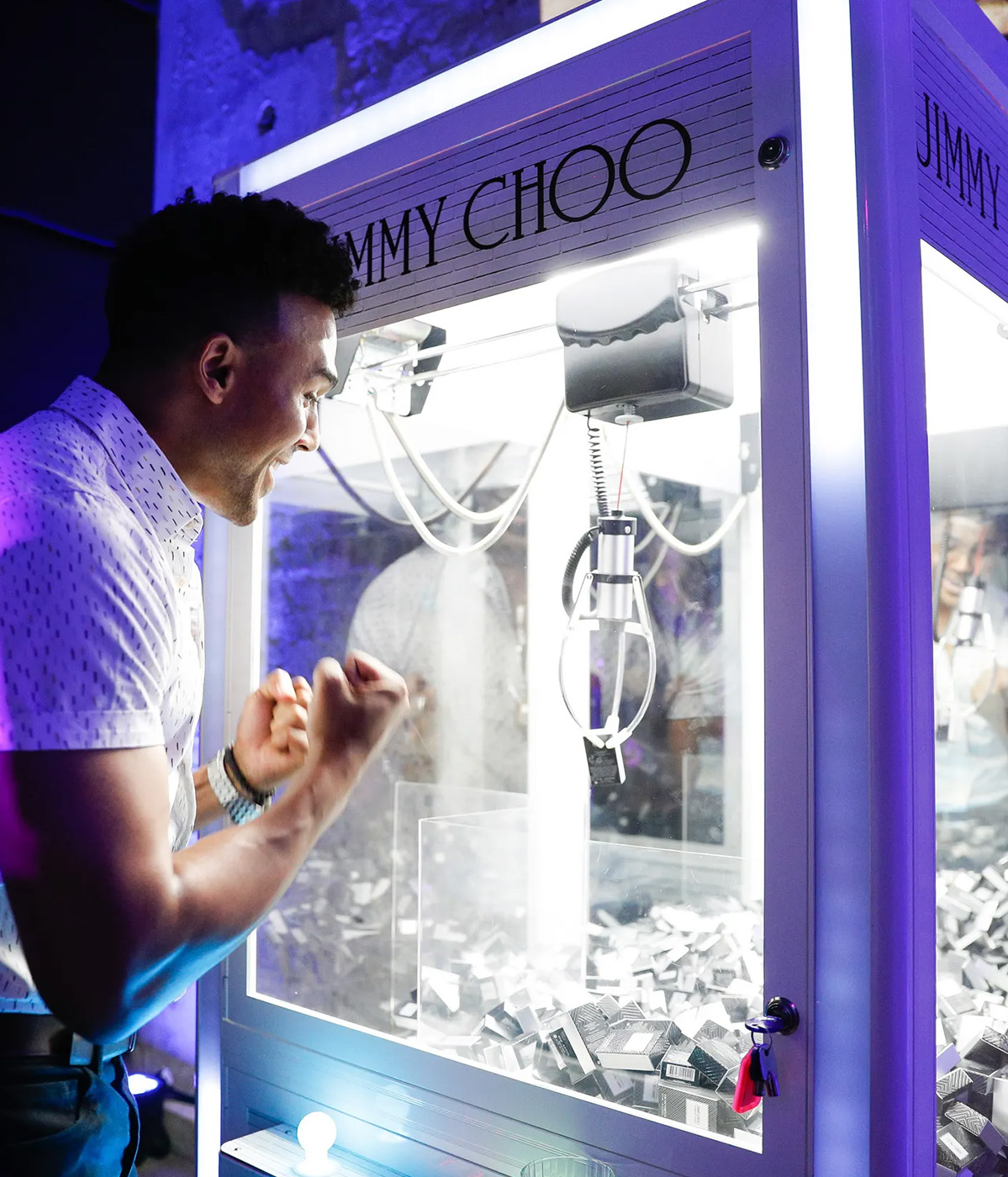 Guest playing a Jimmy Choo branded claw machine at an event
