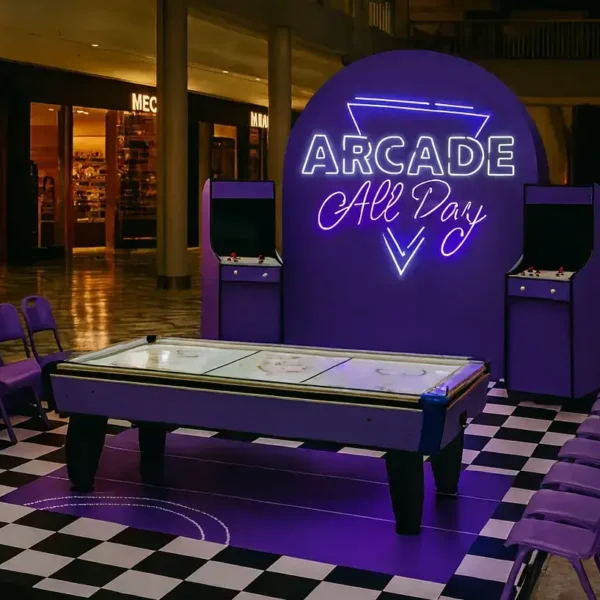Arcade All Day neon branded arcade machine setup at a live event