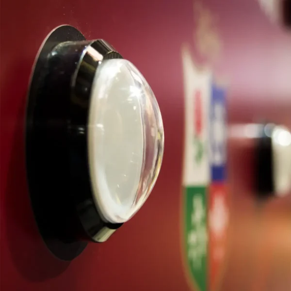 Finger pressing illuminated reaction button on Batak reflex game