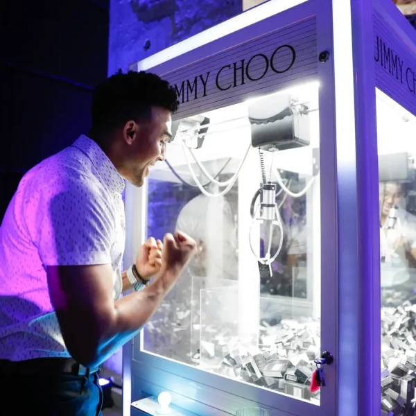 Guest reacting during a game on a Jimmy Choo branded claw machine