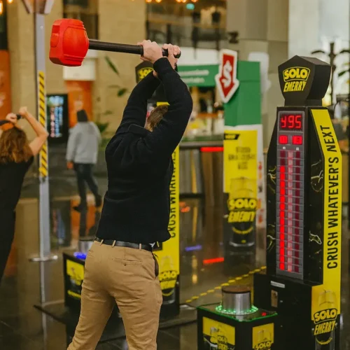 Player using high striker hammer game at Solo Energy activation