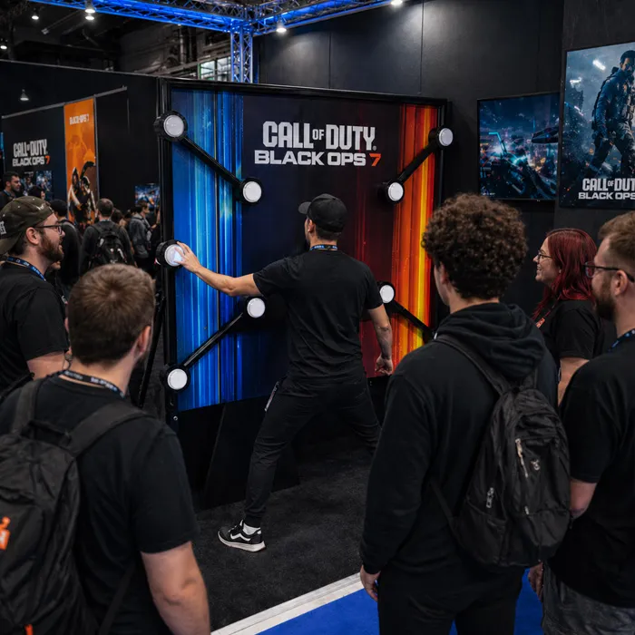 Call of Duty branded reaction wall game with a player and crowd at a gaming expo booth.