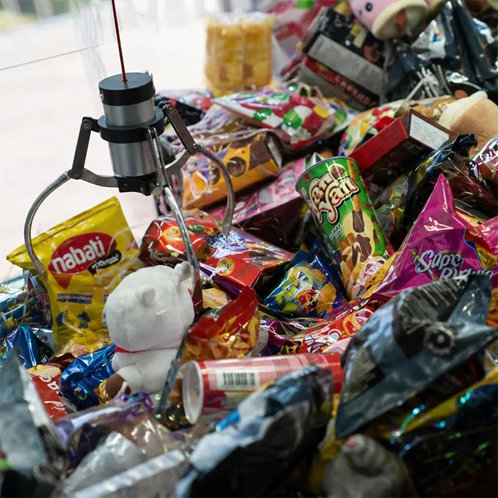 Close-up of assorted prizes inside a wedding claw machine hire setup.
