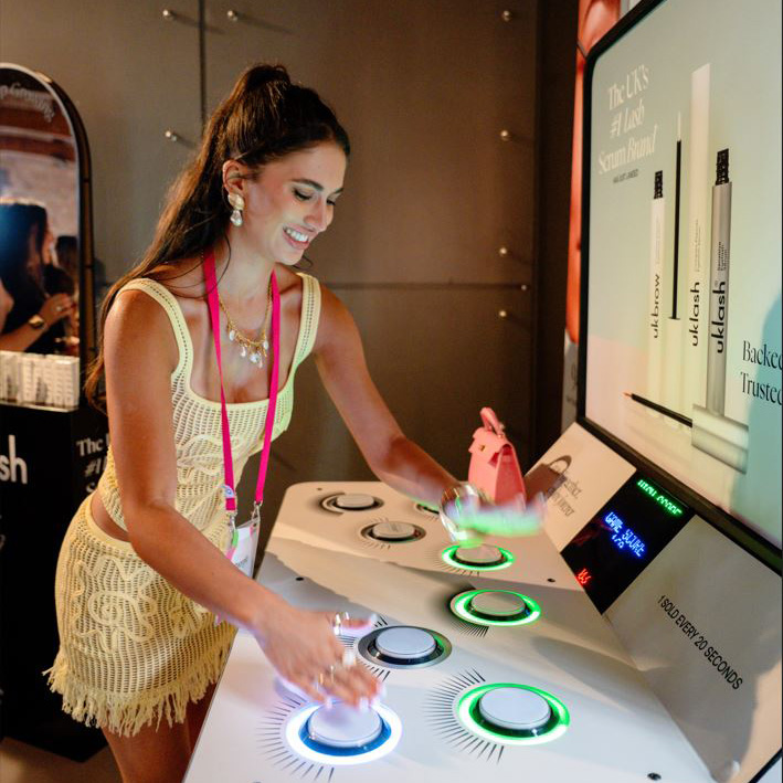 Woman playing a light-up reaction game with illuminated buttons at an event