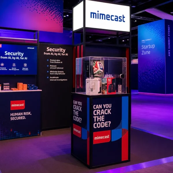 Mimecast branded prize safe activation at AWS Summit with clear acrylic lock box and “Can You Crack the Code?” signage.